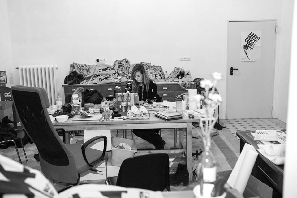 Vera konzentriert am Laptop inmitten eines kreativen Chaos